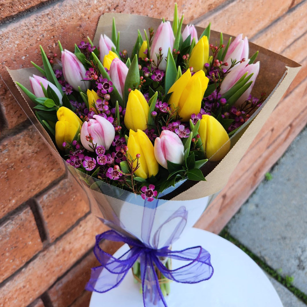 Bouquet of pink and yellow tulips with purple filler flowers