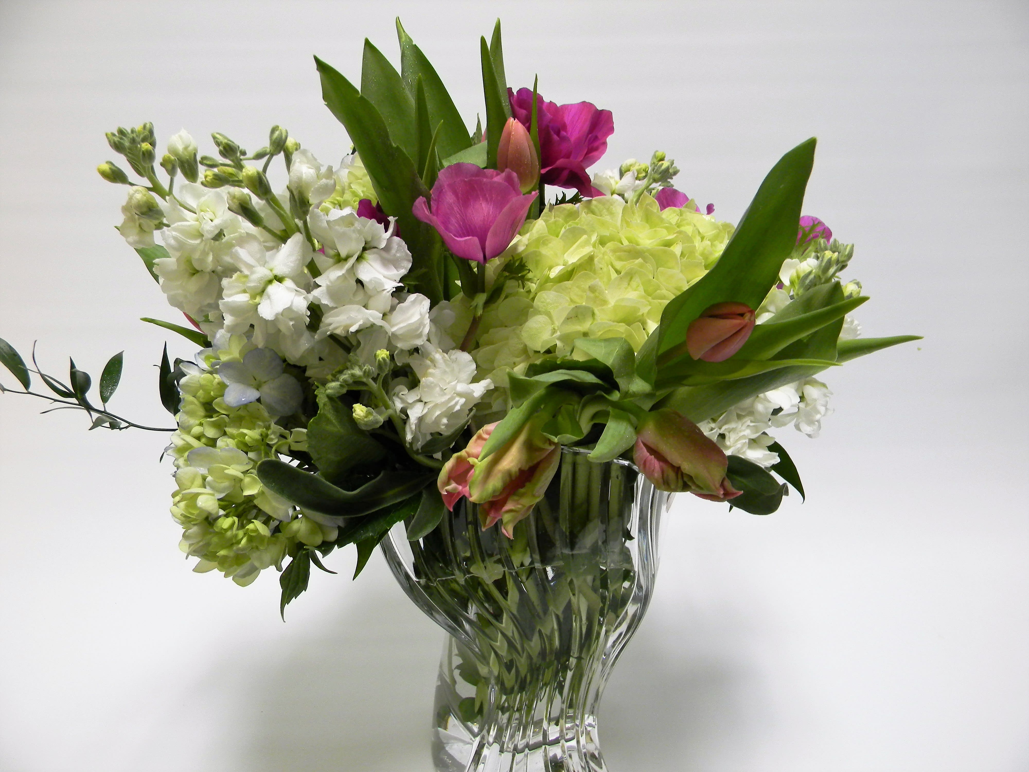 Mixed bouquet of white and pink flowers in a clear glass vase
