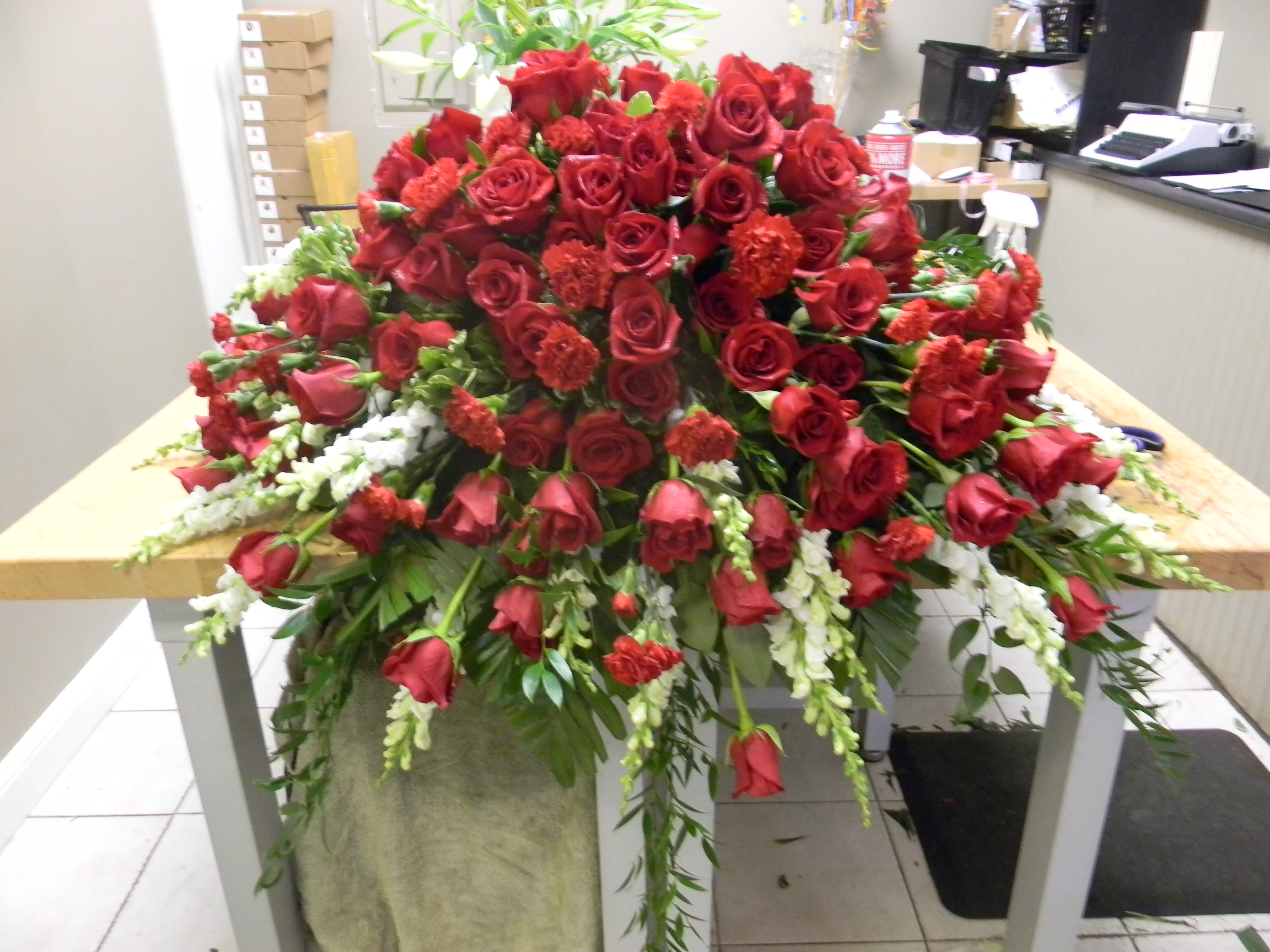 Large arrangement of red roses with white accents on a table