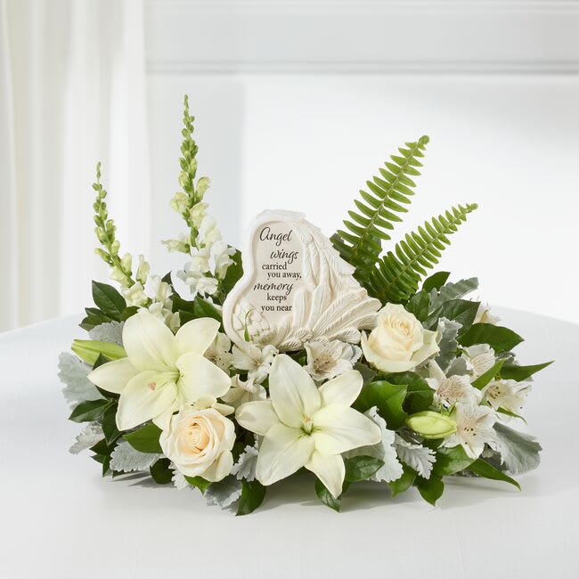 White floral sympathy arrangement with a memorial stone centerpiece