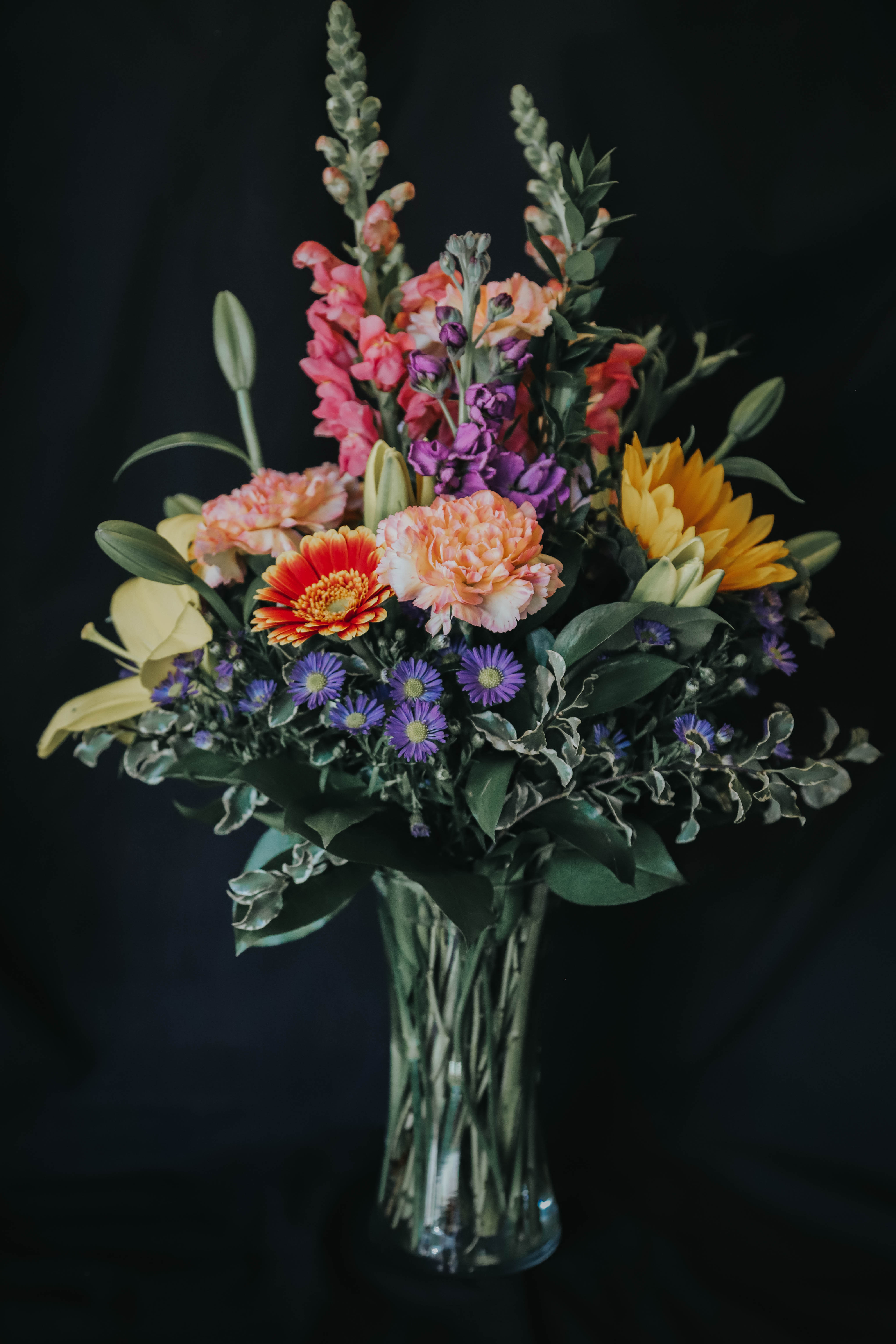 Mixed bouquet of colorful flowers in a clear glass vase