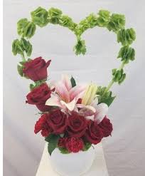 Heart-shaped floral arrangement with red roses and lilies