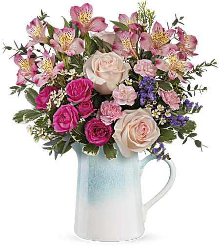 Pink and cream roses with alstroemeria in a blue ceramic pitcher