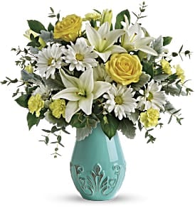 Yellow roses and white lilies in a turquoise vase