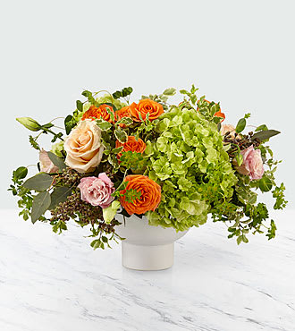 Fresh Glow  - Whether it's for saying "I hope this brightens up your day" or "You make me happy", give this arrangement to someone special. Our Fresh Glow Bouquet is comprised of green hydrangea, peach roses, orange spray roses, and pink double lisianthus and placed in a white ceramic bowl. Give this gift to a loved one or yourself to add a touch of beauty to any room its placed.  Bouquet is approx. 11"H x 17"W. 