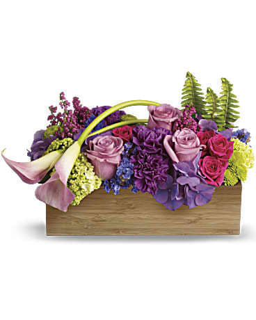 Ticket to Paradise Bouquet - As lush and serene as a tropical sunset, this paradise of feminine blooms is a unique way to send your best wishes. The well-balanced arrangement is both chic and Zen, with its graceful callas, enchanting color palette and modern bamboo container.  Lavender hydrangea, lavender roses, light pink miniature calla lilies, hot pink roses, purple carnations, green viburnum, green button spray mums, purple statice, delicate pink heather and sword fern are gorgeously gathered into a rectangular bamboo container.