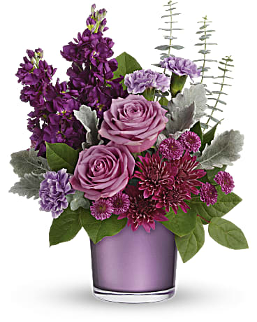 Purple and pink flower arrangement in a lavender vase