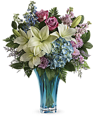 Heart's Pirouette Bouquet  - Her heart will dance when this breathtaking bouquet arrives! Bursting with blue and pink blooms, this enchanting azure vase is carefully crafted of blown glass in a stunning swirled design, it's a décor keepsake like no other.  This arrangement features blue hydrangea, lavender roses, white asiatic lilies, light blue delphinium, light pink stock, lavender cushion spray chrysanthemums, misty blue limonium, leatherleaf fern, and lemon leaf. Delivered in a Heart's Pirouette vase. Approximately 19 1/2" W x 23" H  SUBSTITUTION POLICY – Always deliver the freshest flowers! Please note the bouquet pictured reflects our original design.  If the exact flowers or container in this arrangement are not available, we will create a beautiful bouquet with the freshest available flowers.