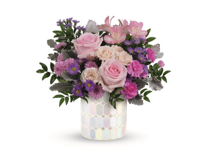 Pink roses and purple flowers in a patterned ceramic vase