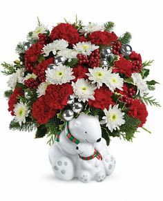 Red and white floral arrangement with a white teddy bear base