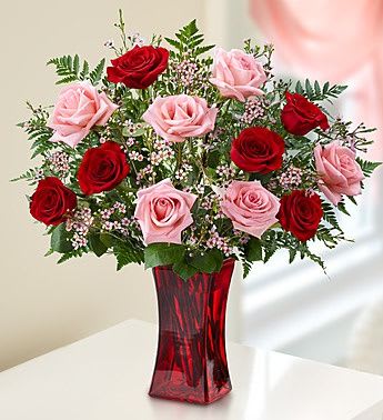 Red and pink roses in a red glass vase