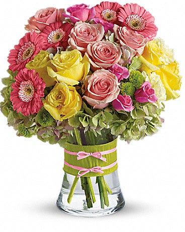 Pink and yellow roses with pink gerbera daisies in a glass vase