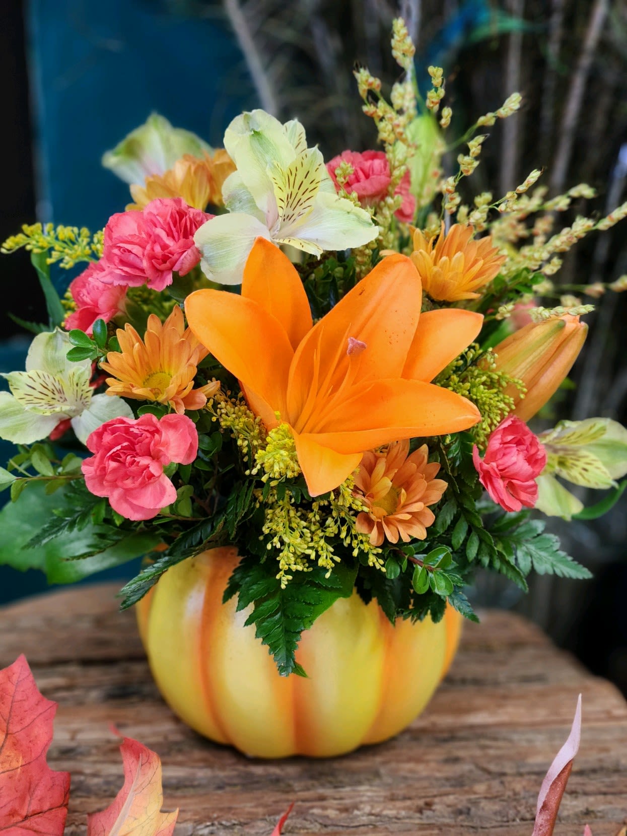 Orange and pink mixed bouquet in a pumpkin-shaped vase
