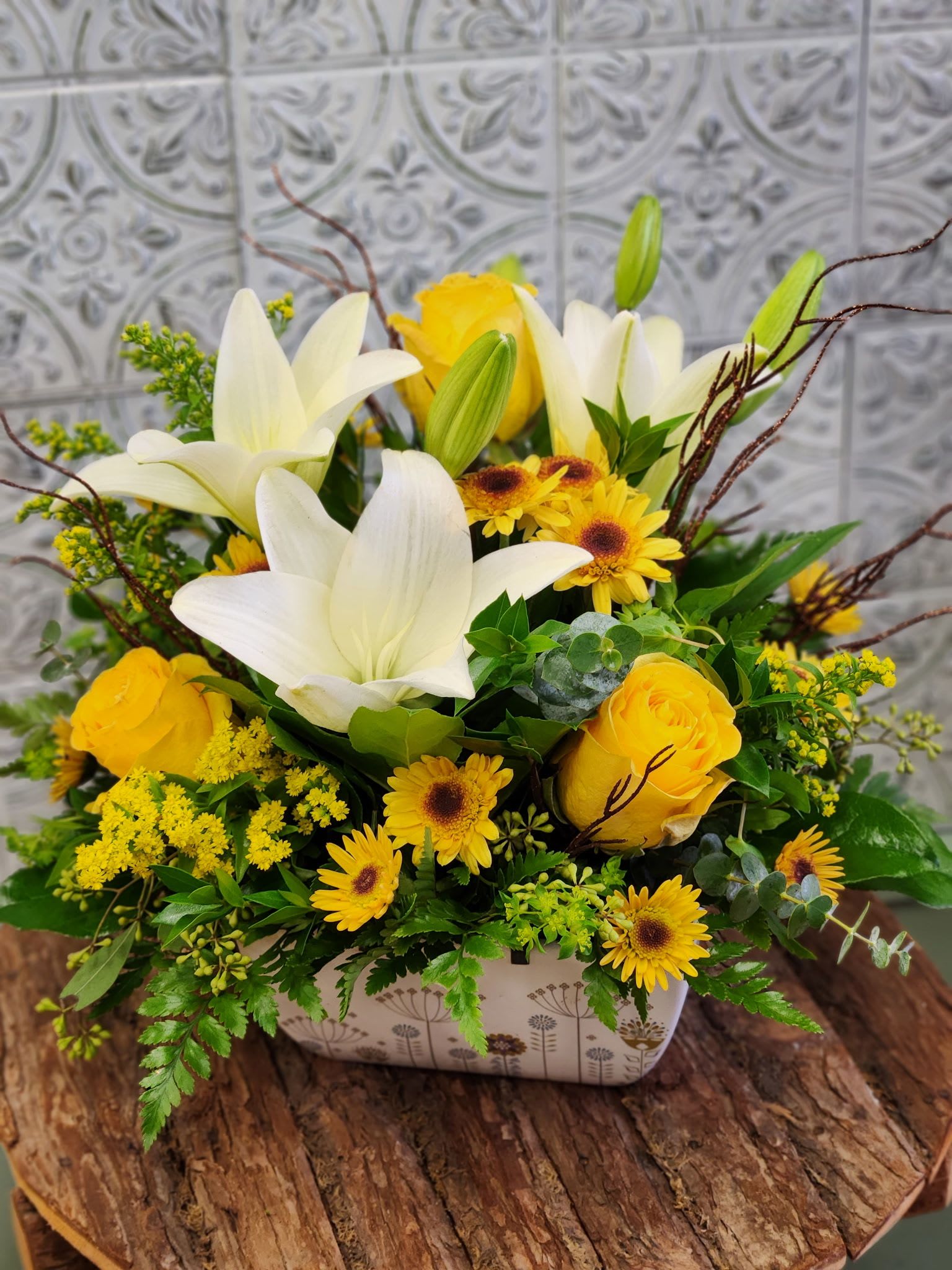 Yellow and white floral arrangement in a rectangular container