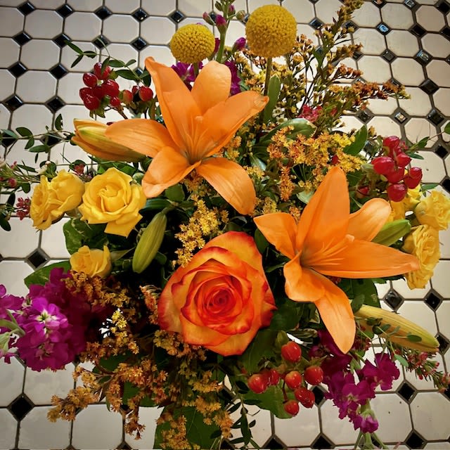 Bouquet with orange lilies, orange rose, yellow roses, and purple flowers