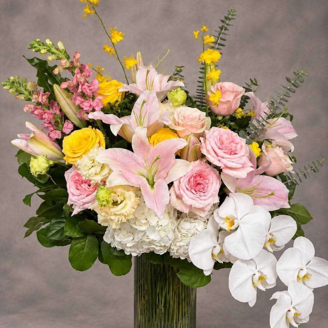 Large bouquet of pink and white flowers in a clear glass vase