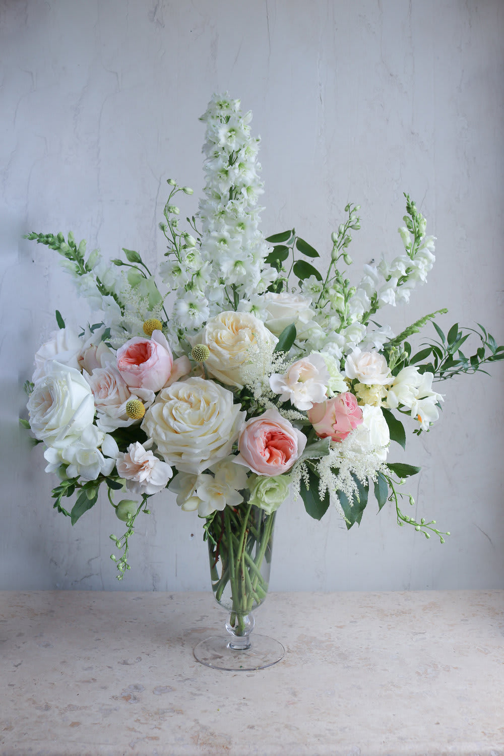 White and blush floral arrangement in a clear glass vase
