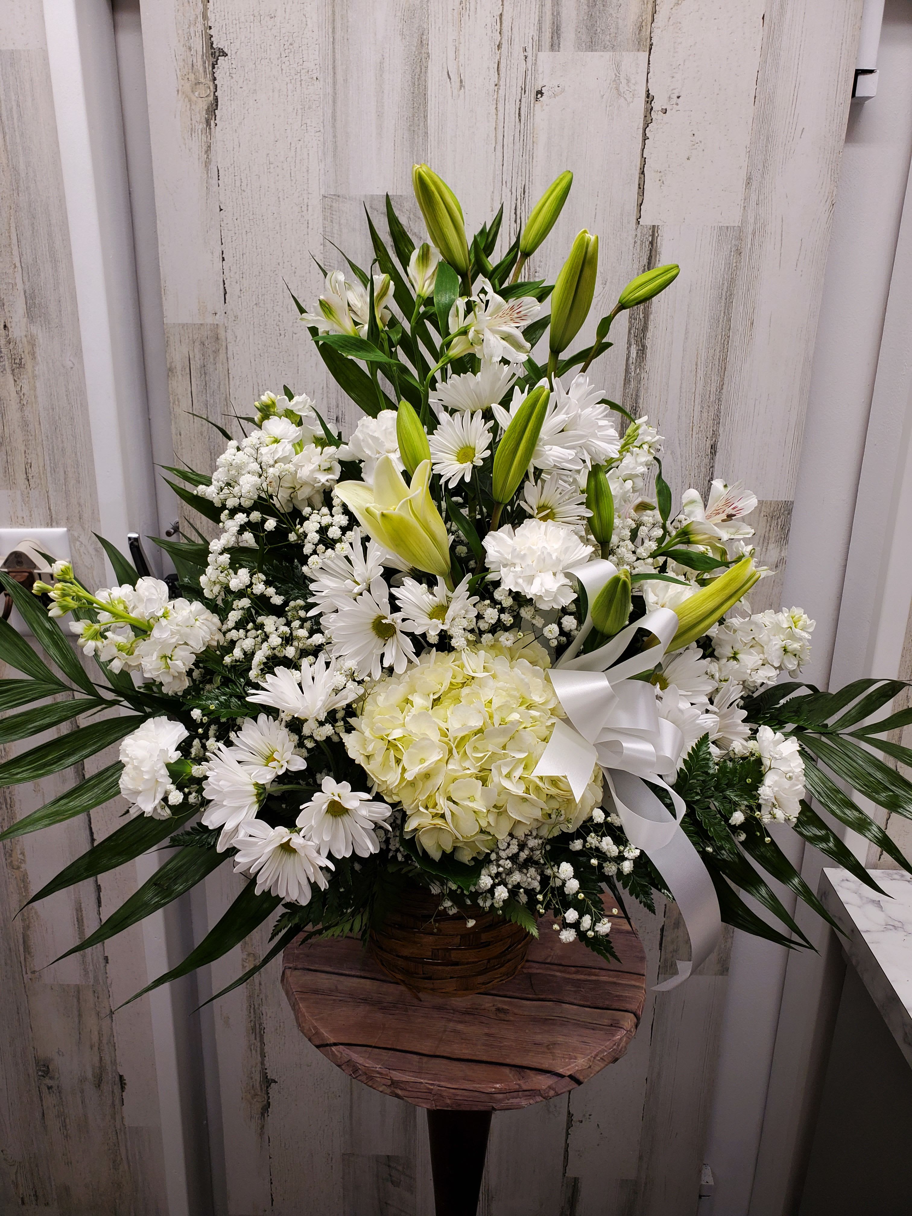 Eden - White alstroemeria, snapdragons and stock in a beautiful basket is a gift of caring that brings an air of serenity to the memorial service. Later, it will be a comfort for the family at home. 