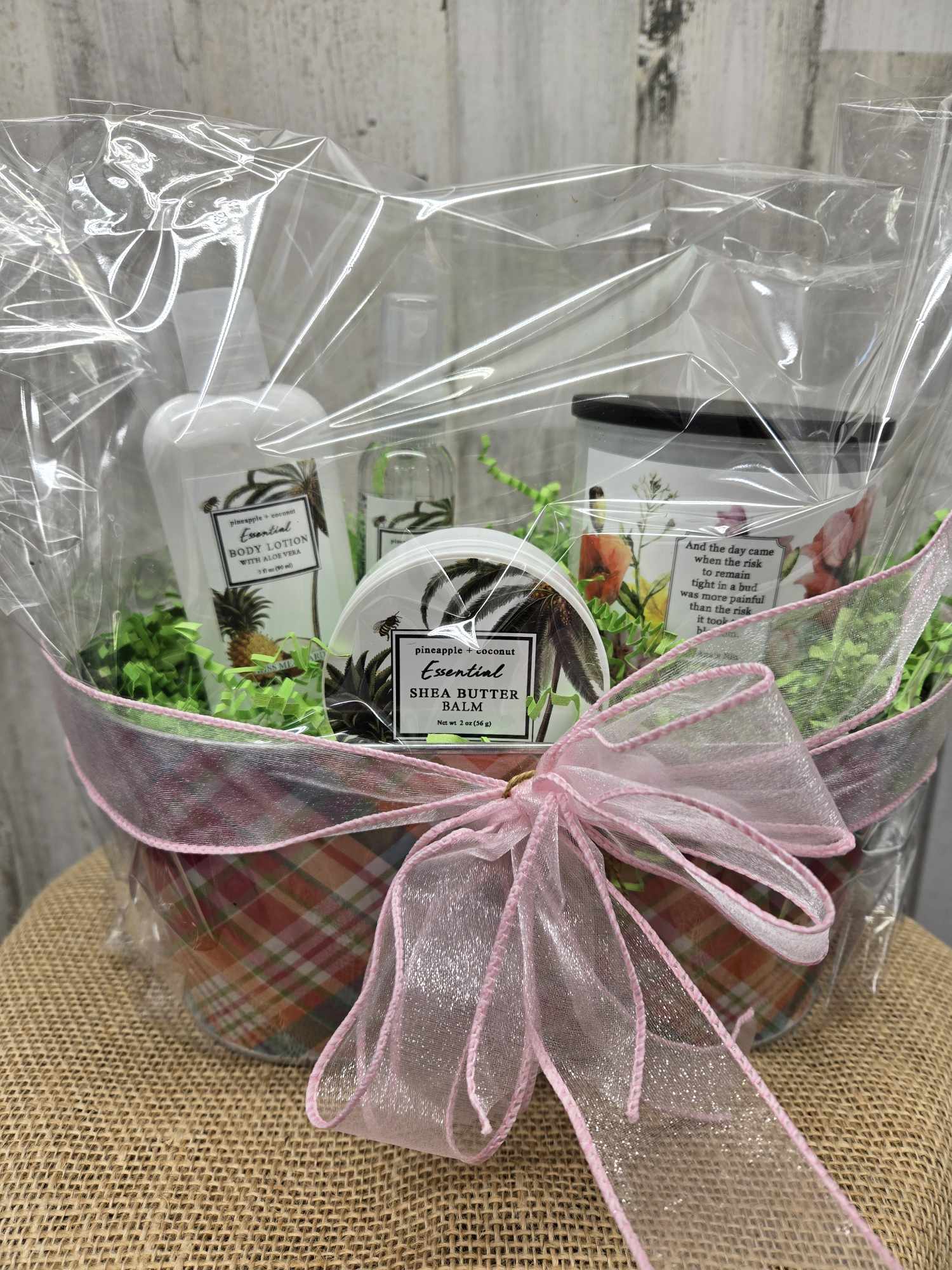 Gift basket with body lotion, shea butter balm, and a pink ribbon