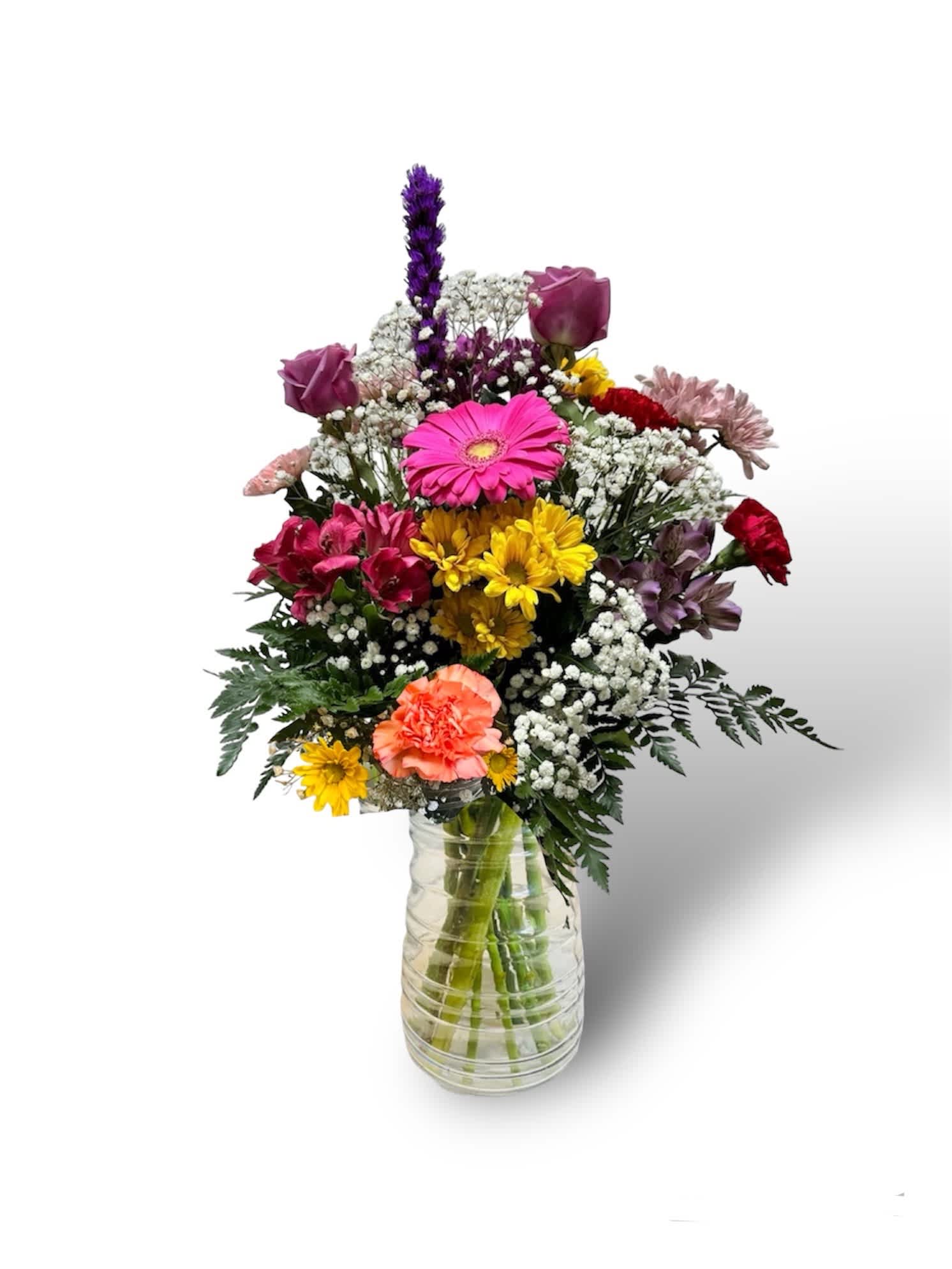 Mixed bouquet of colorful flowers in a clear glass vase