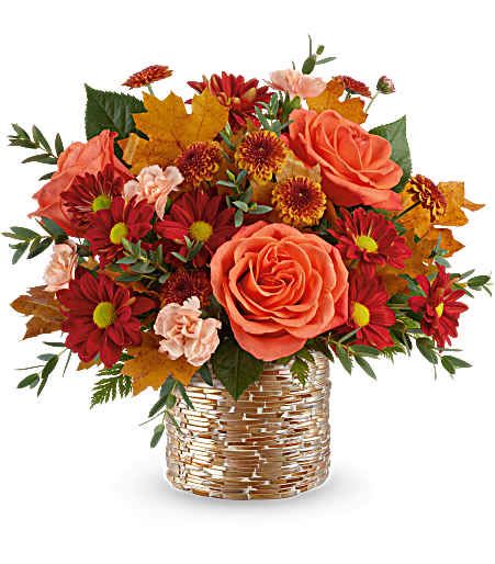 Orange roses and red daisies in a woven basket