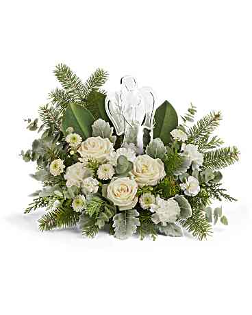White roses and greenery arranged around a clear cross ornament