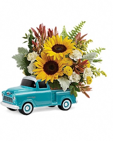 Sunflowers arranged in a turquoise toy truck planter