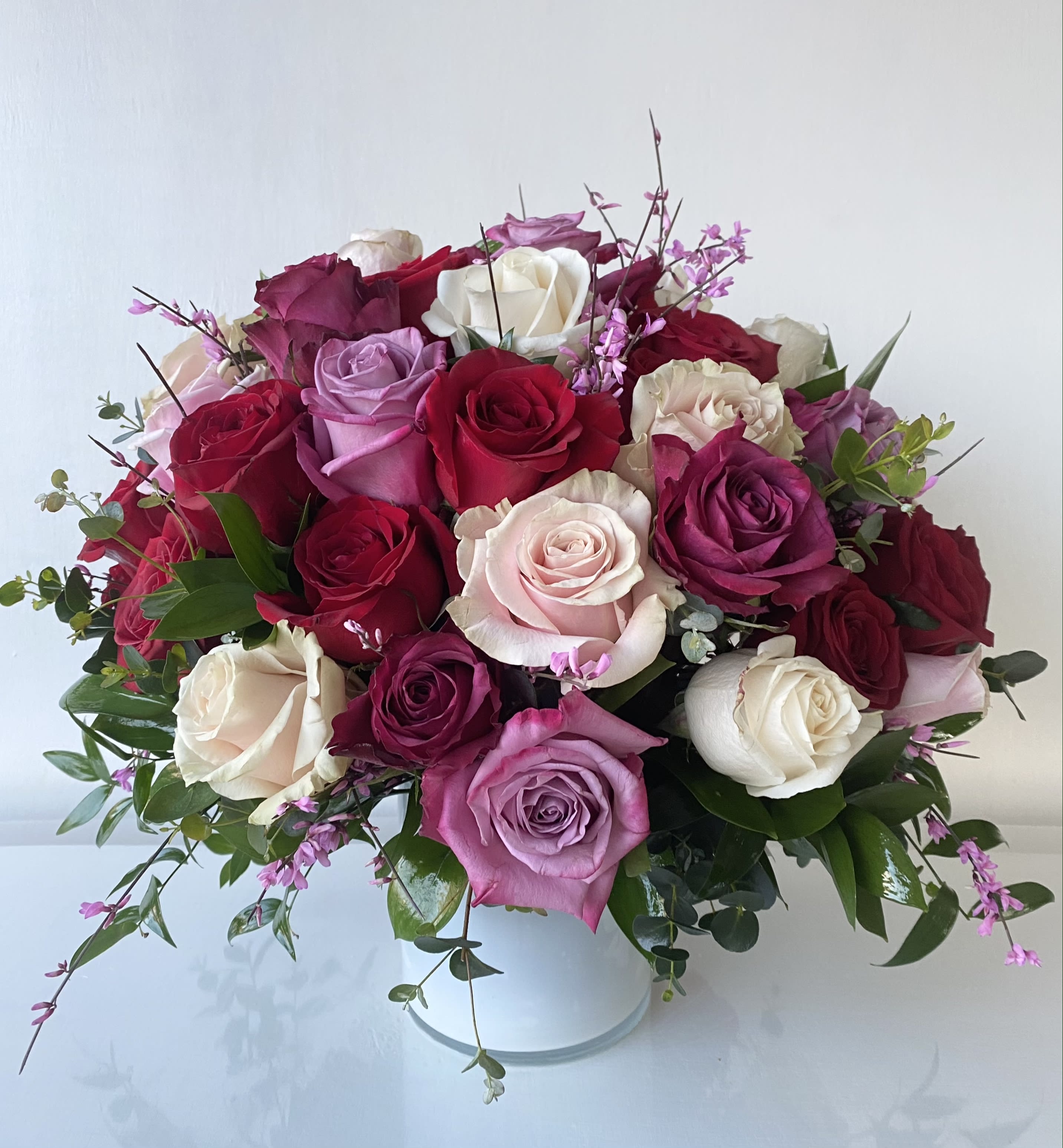 Bouquet of roses in pink, red, and white in a white vase