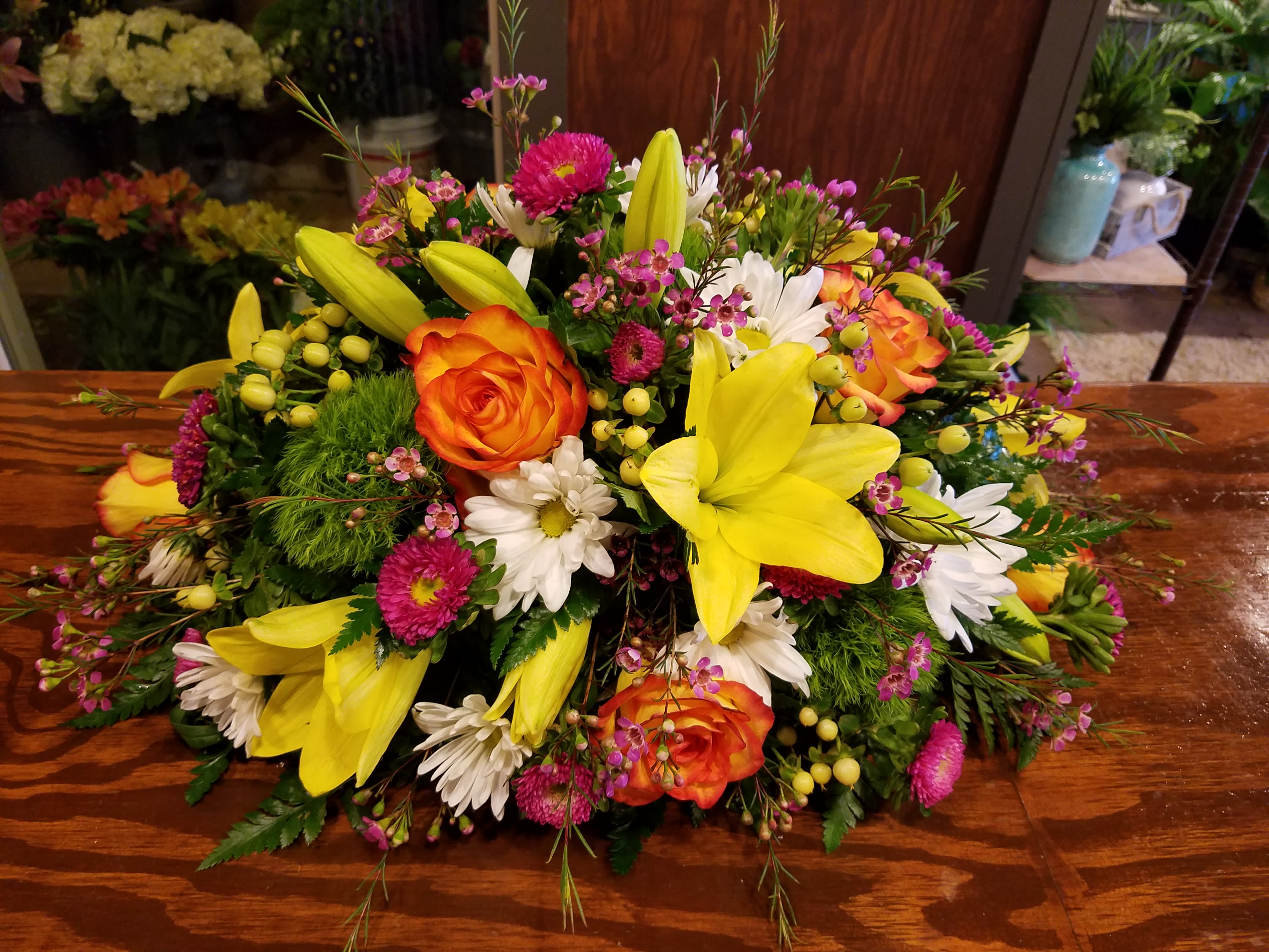 Bright mixed bouquet with yellow lilies, orange roses, and white daisies