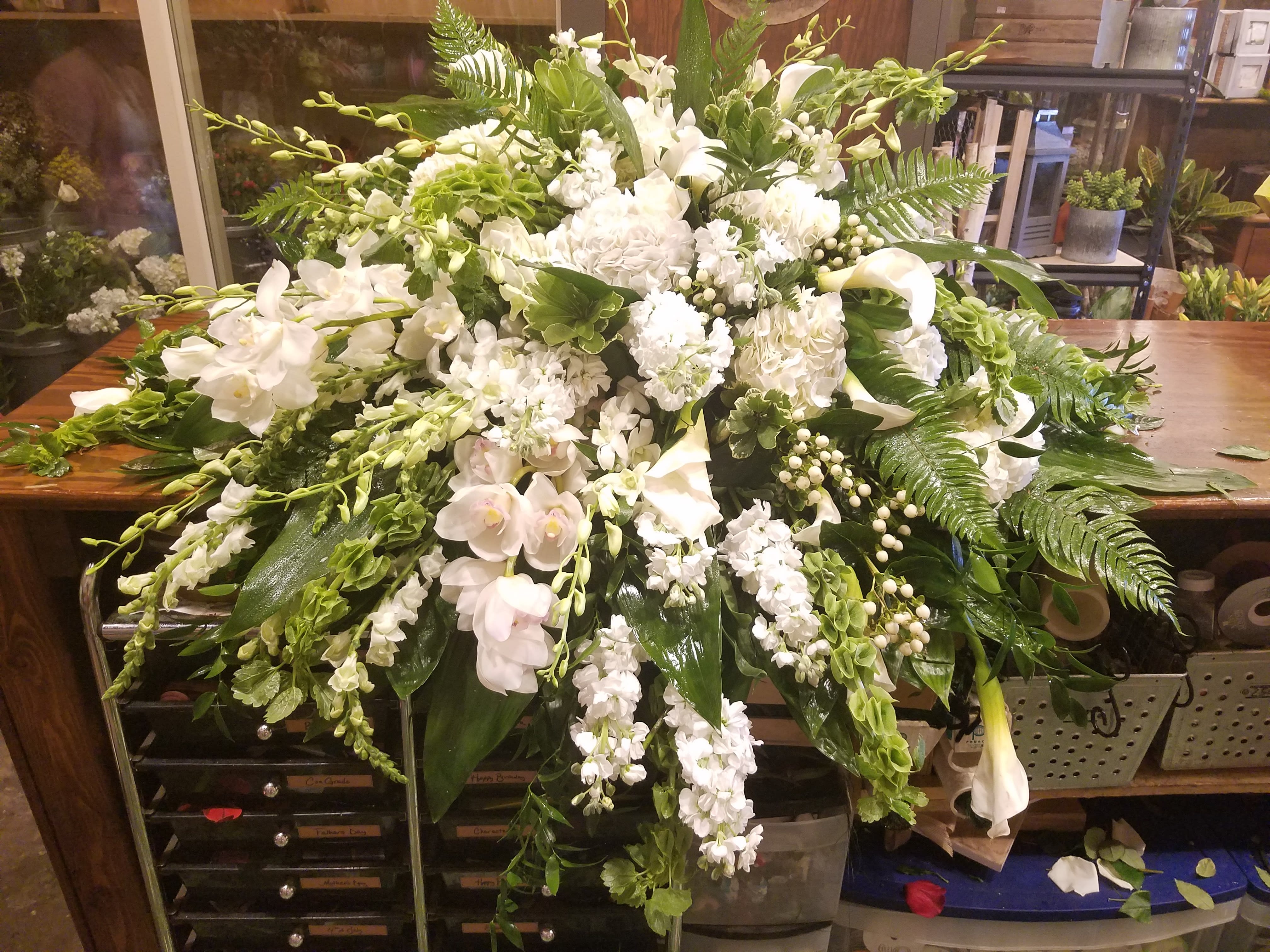 Sweet memories - All white casket arrangement with a large assortment of white flowers that includes orchids. 