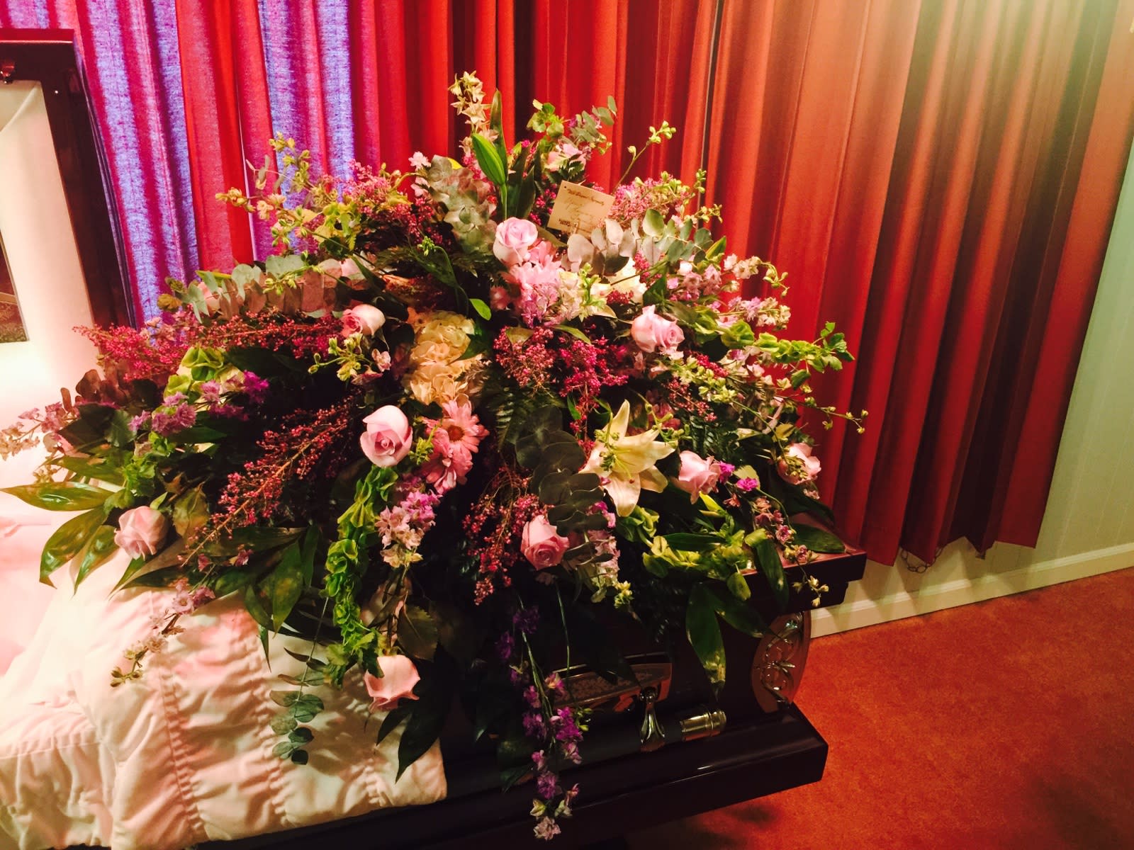Large floral spray on a casket with pink and white flowers