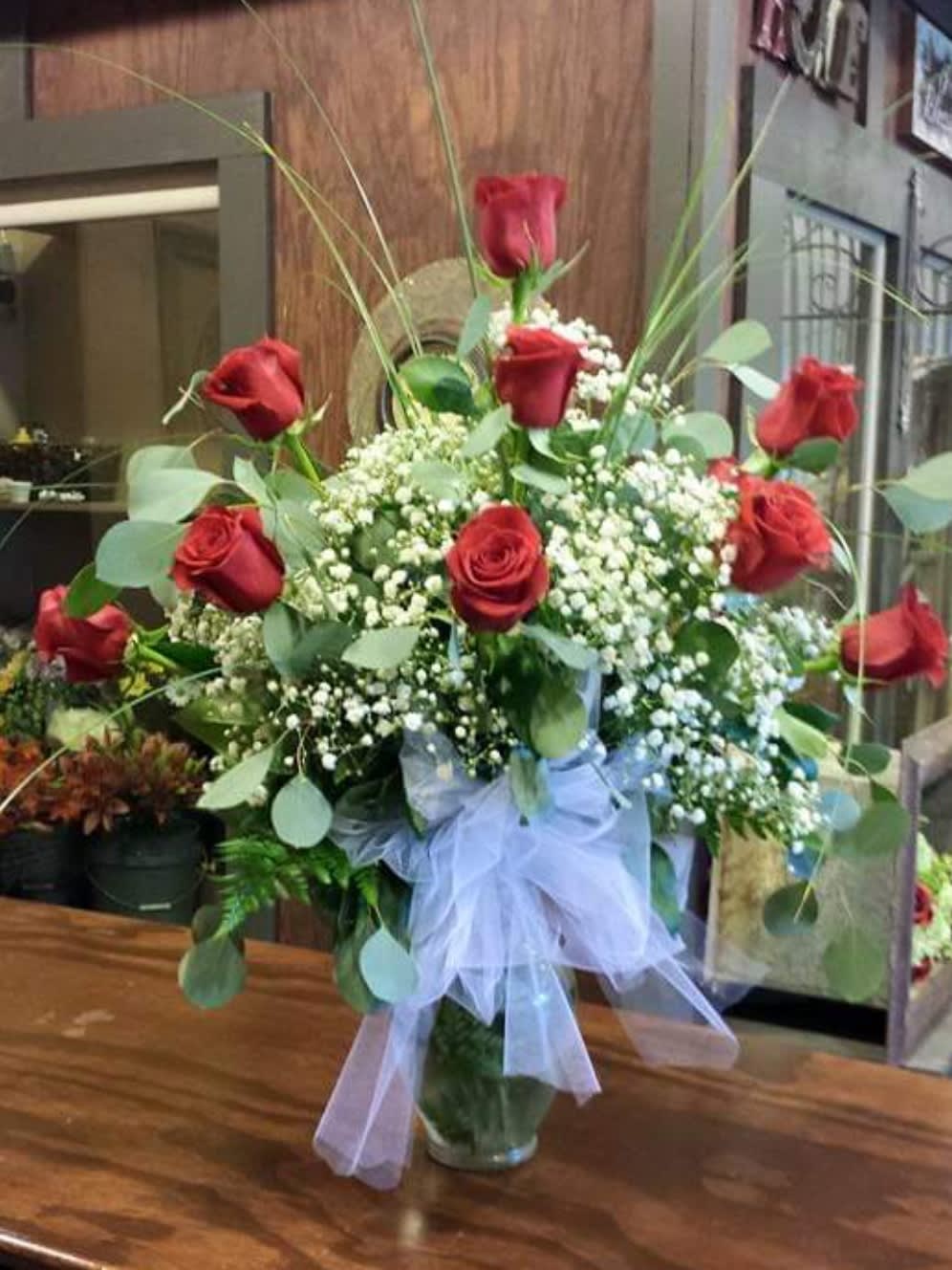 Bouquet of red roses with baby's breath in a glass vase