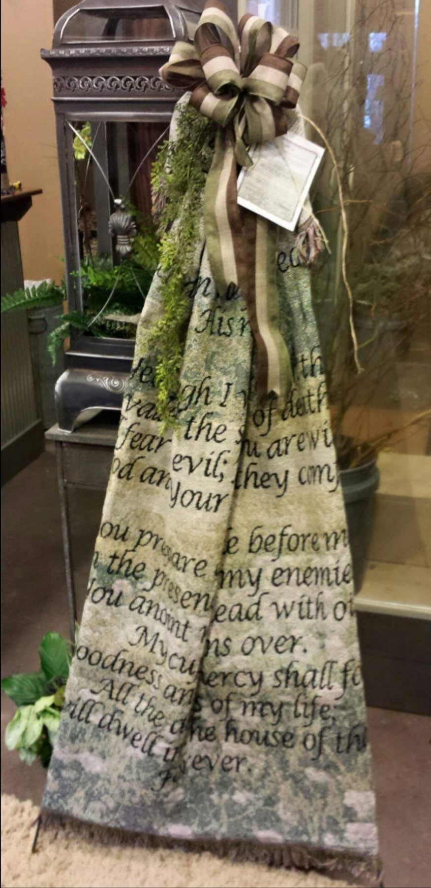 Tall decorative fabric banner with a large striped bow and greenery