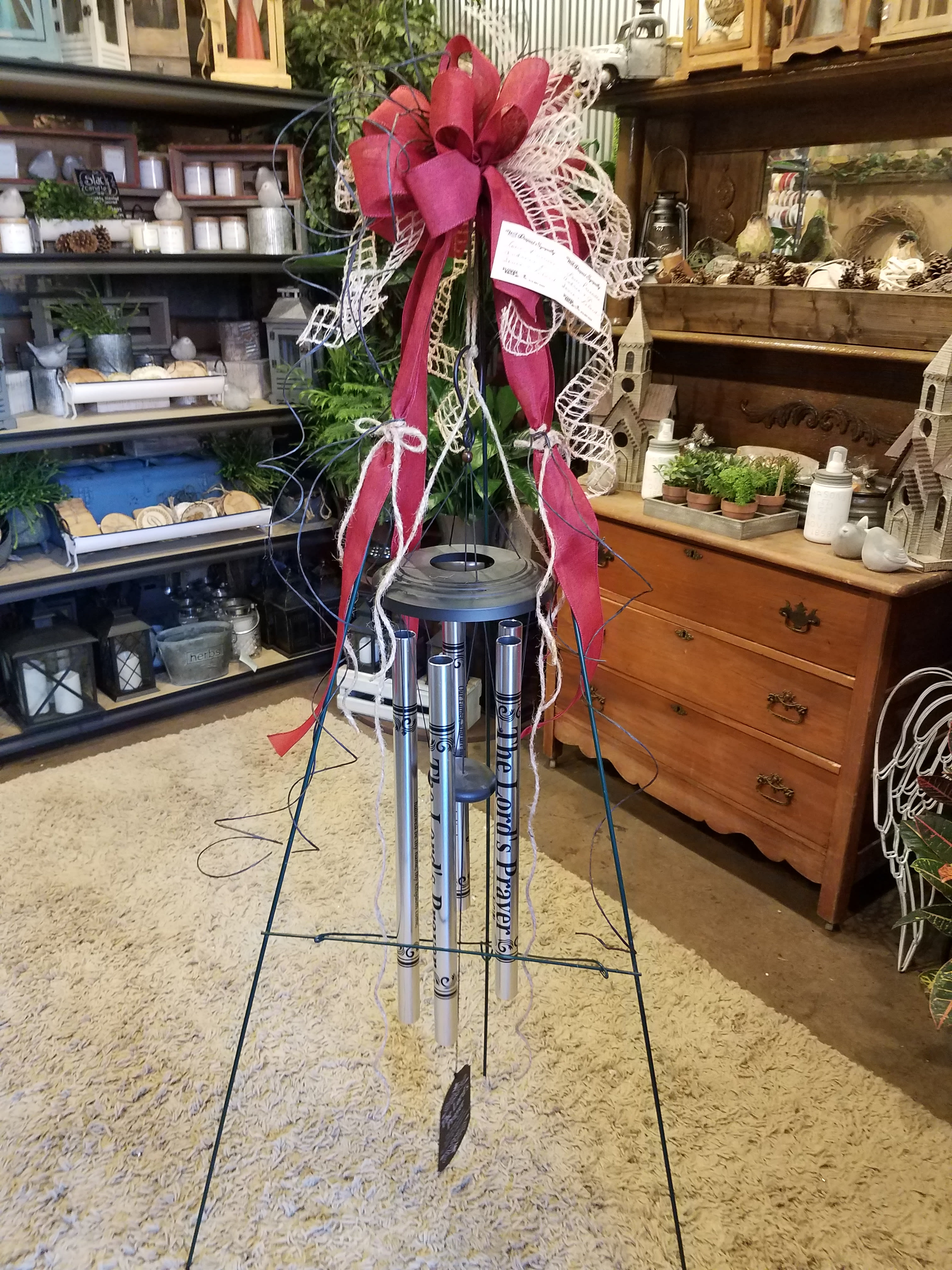 Tall memorial wind chime with a large pink ribbon bow