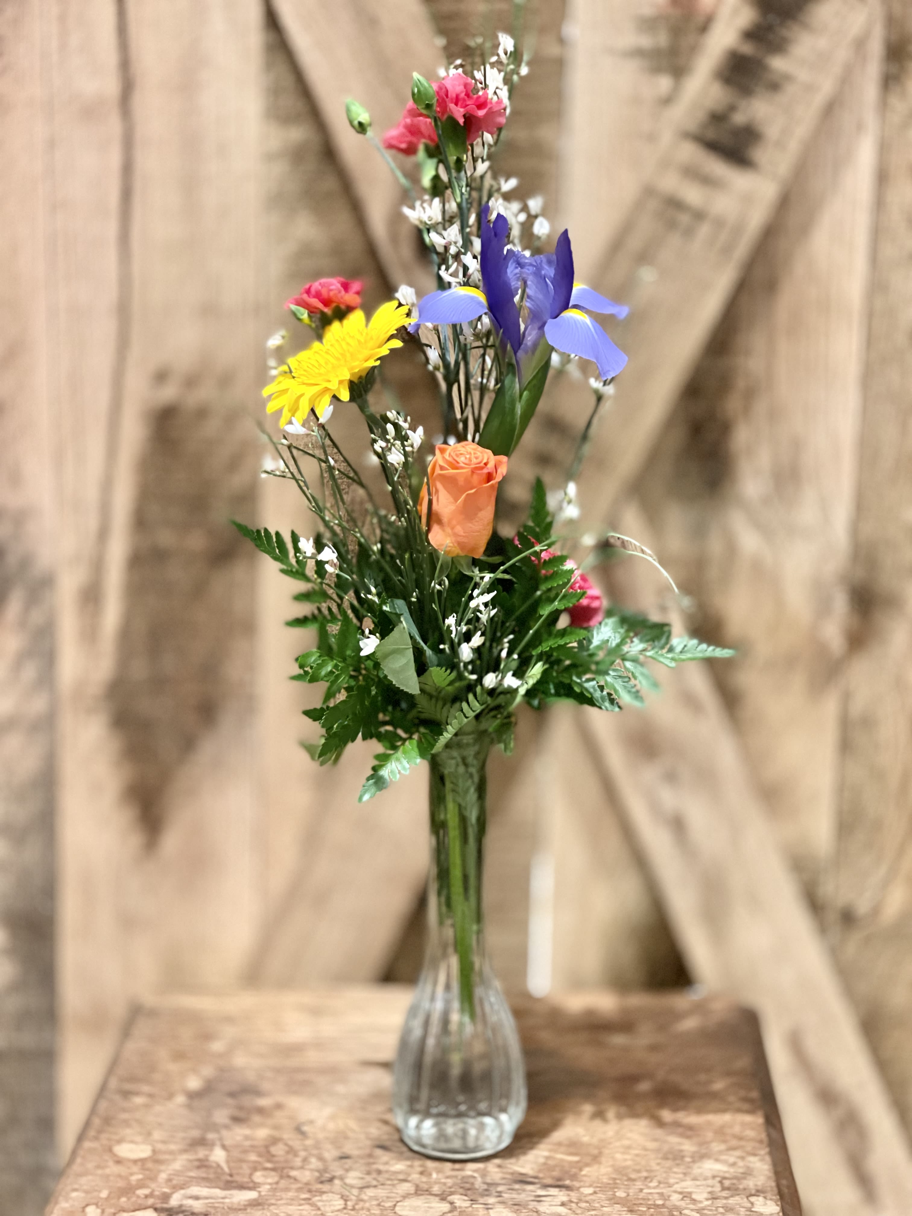 Mixed bouquet of colorful flowers in a clear glass vase