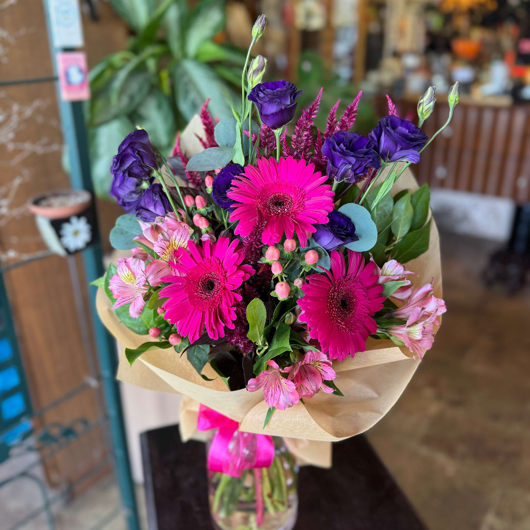 Bouquet of pink gerbera daisies and purple lisianthus in paper wrap
