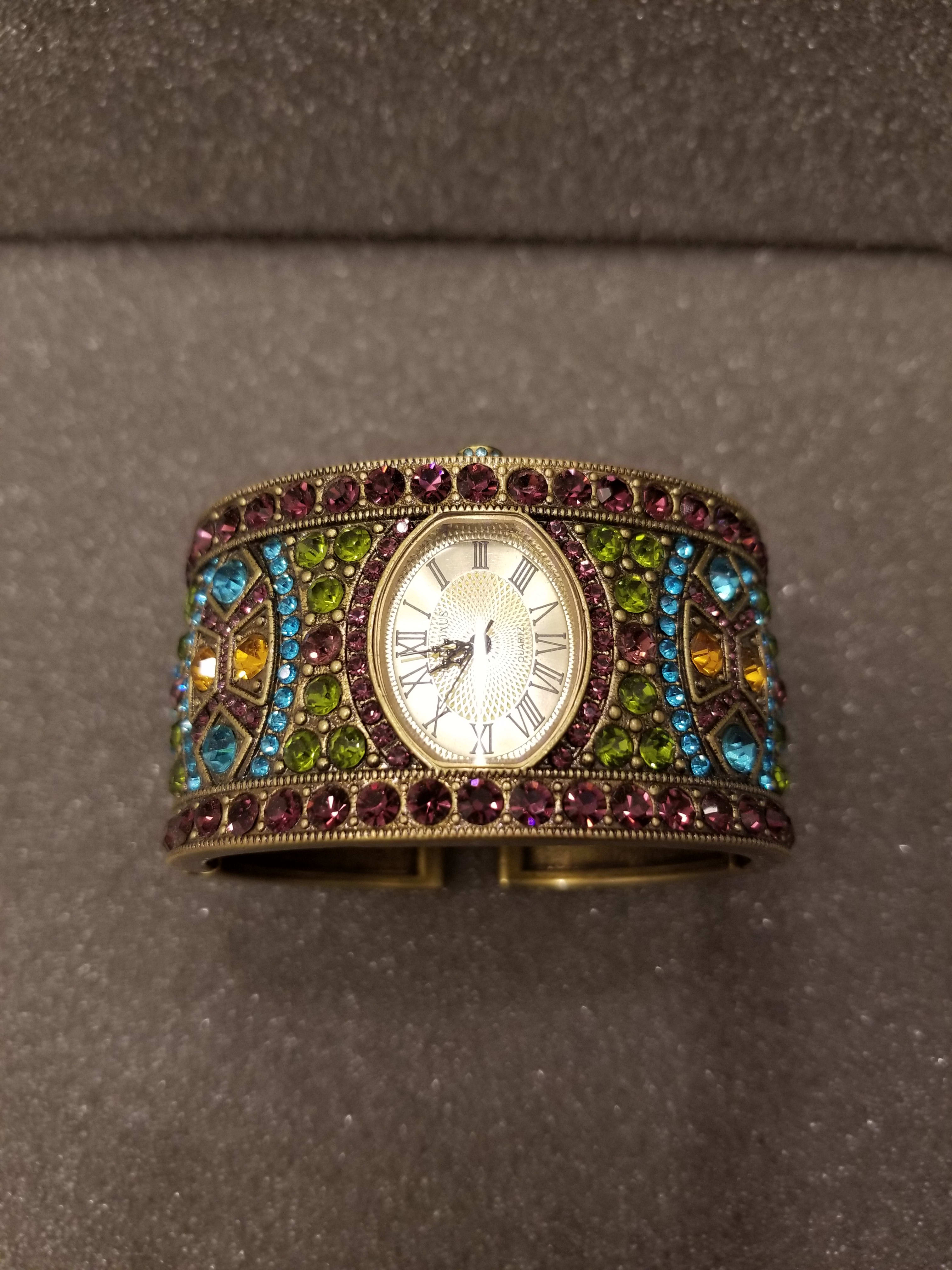 Jeweled wristwatch with a gold-toned face and multicolored stones
