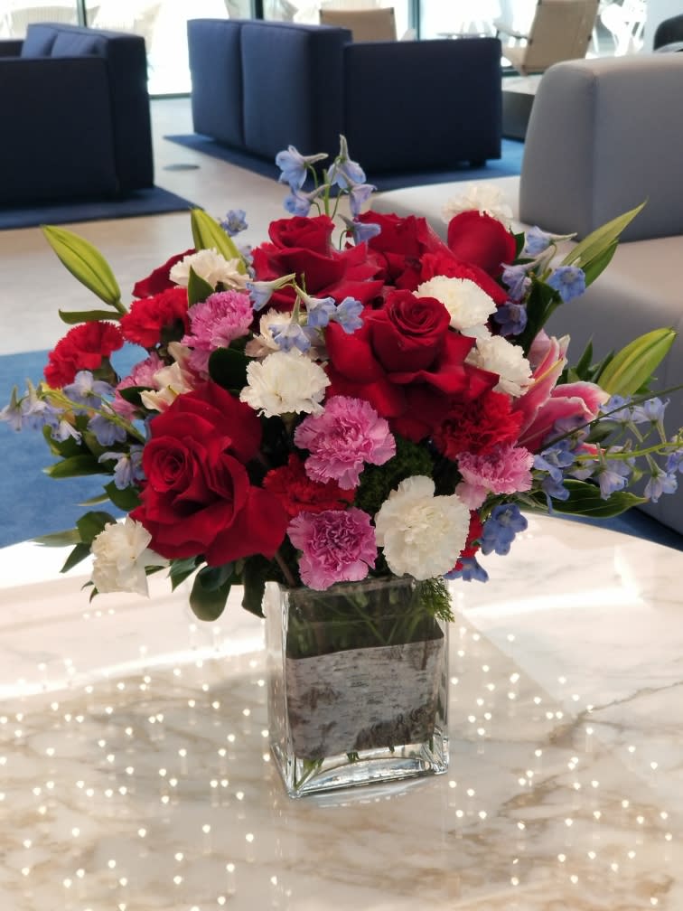 Red roses and pink carnations in a clear glass vase
