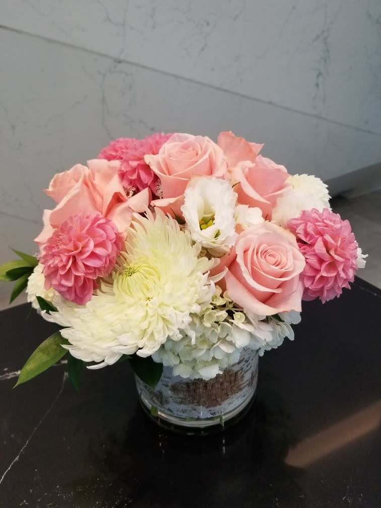 Pink roses and white chrysanthemums arranged in a small vase
