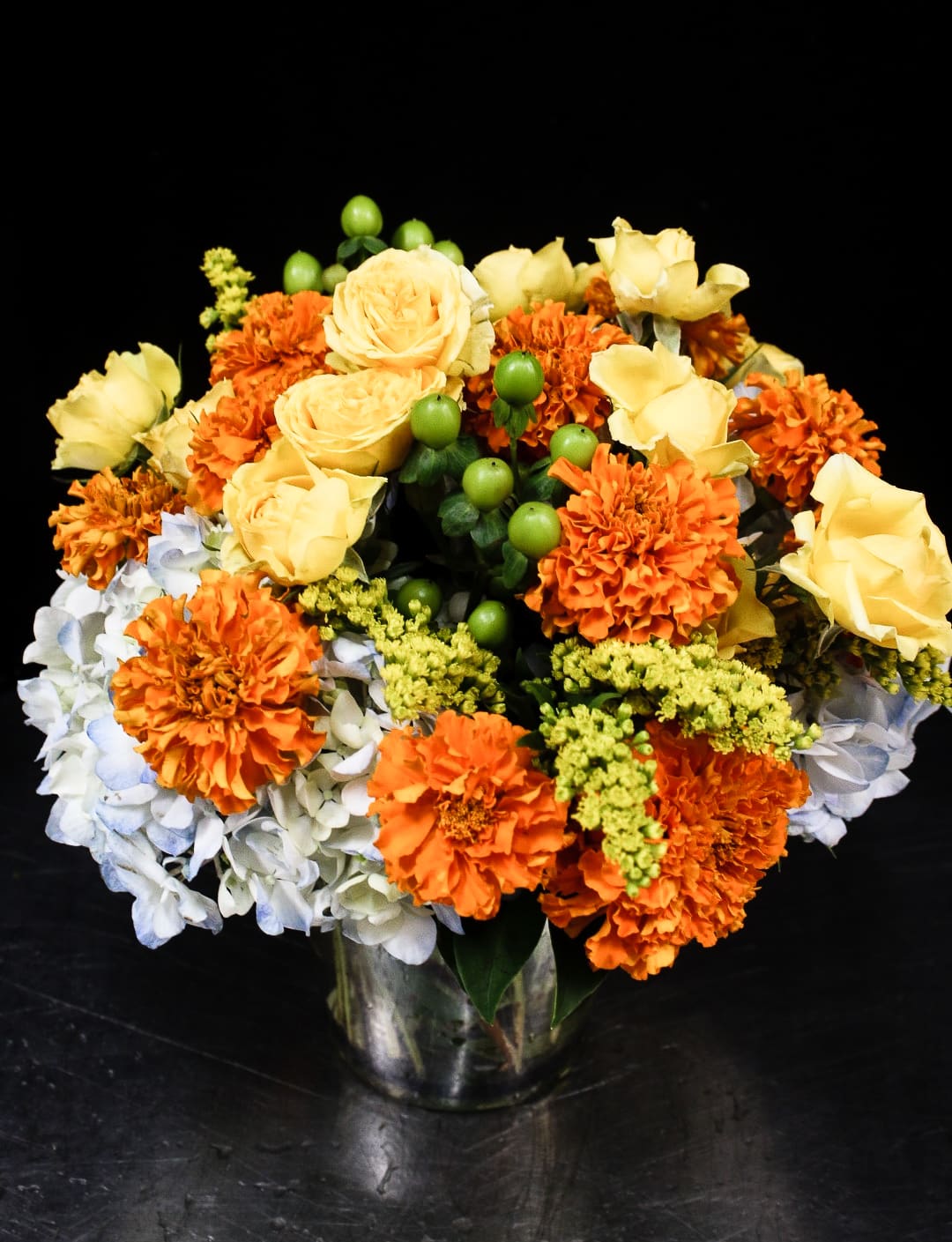 Orange and yellow flower arrangement in a glass vase