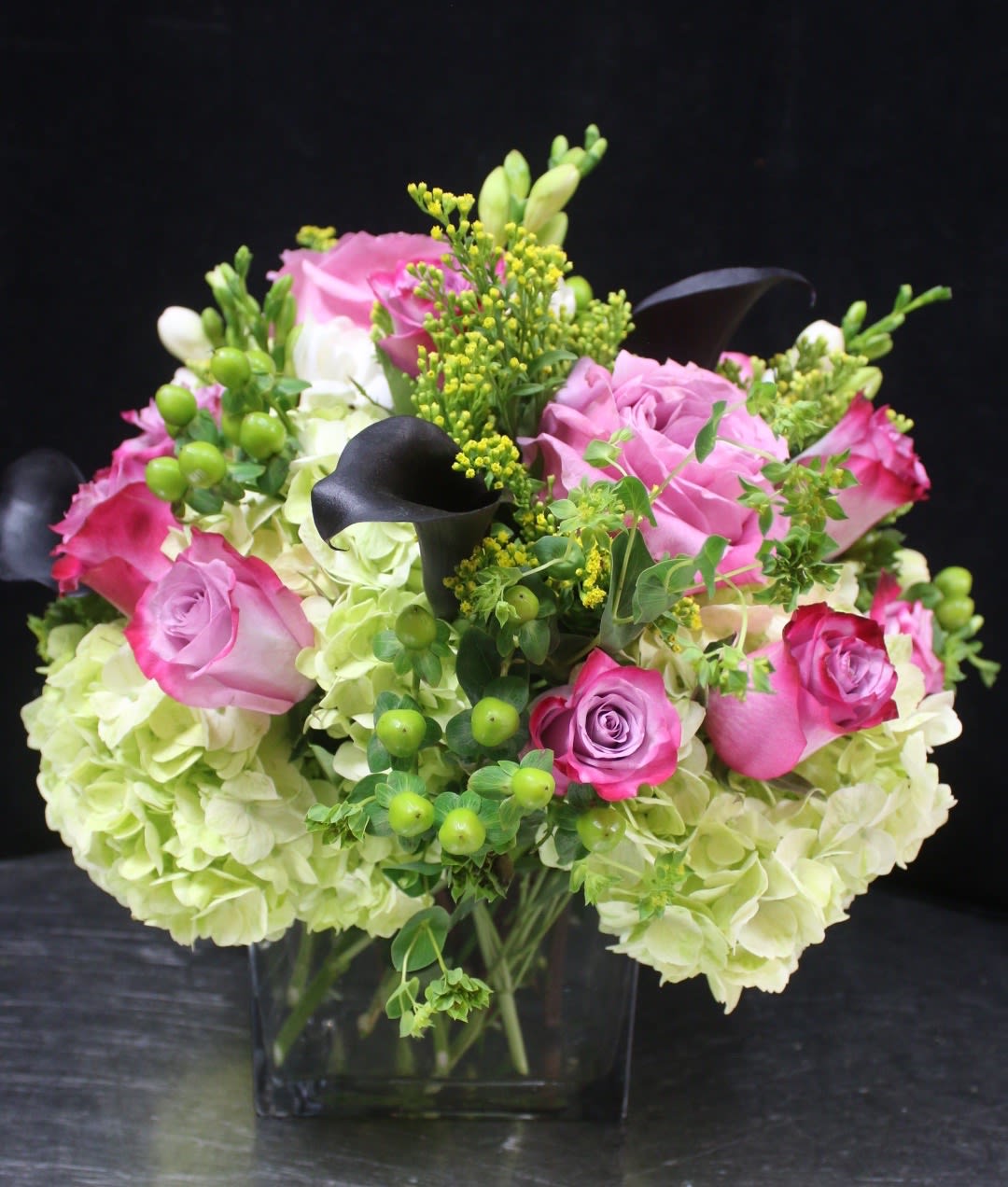 Pink roses and pale hydrangeas in a square glass vase