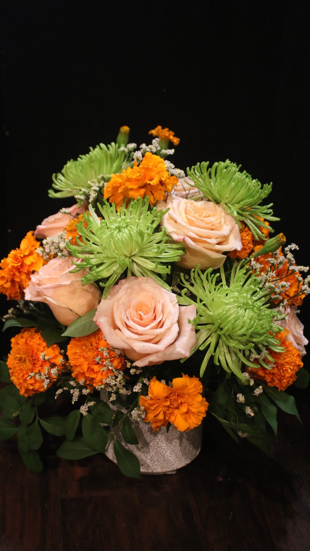 The Mike and Ike - This vibrant arrangement is a mix of seasonal and classic. With elegant roses and funky spider mums this arrangement is perfect to brighten up any home. Green spider mums, marigolds, light pink roses.