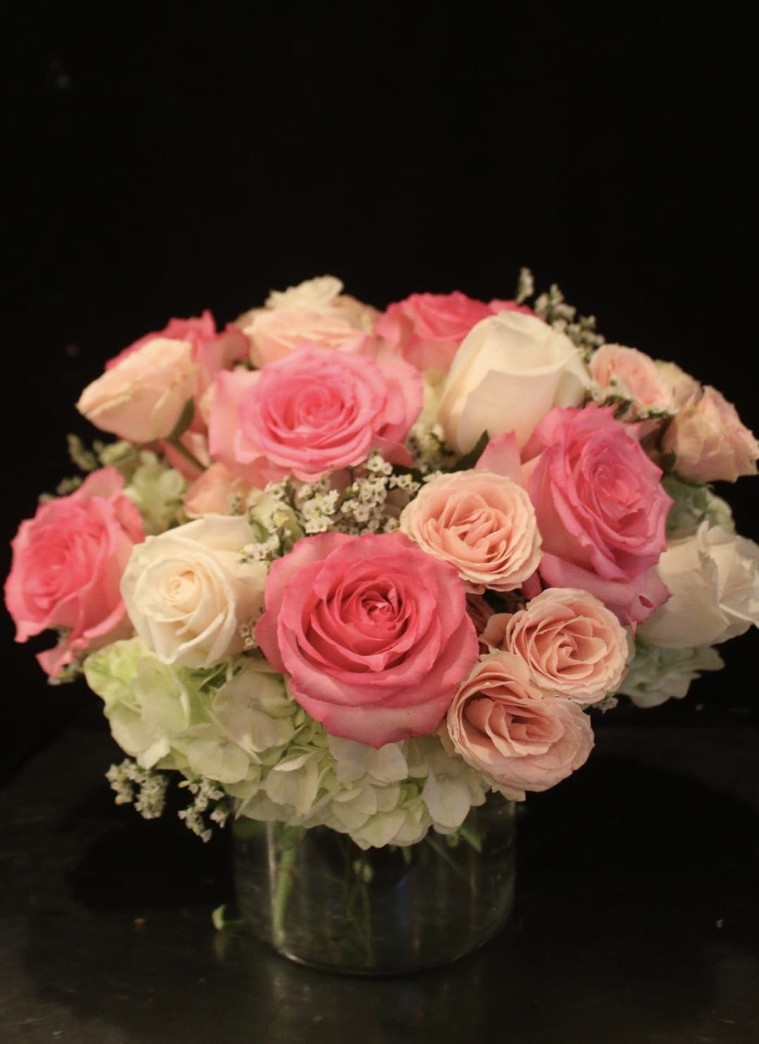 Pink and white roses arranged in a clear glass vase