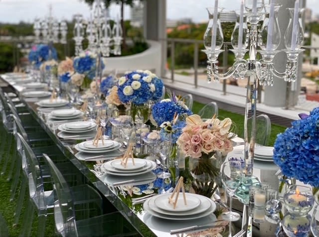 Long banquet table with blue and blush floral centerpieces and crystal candelabras