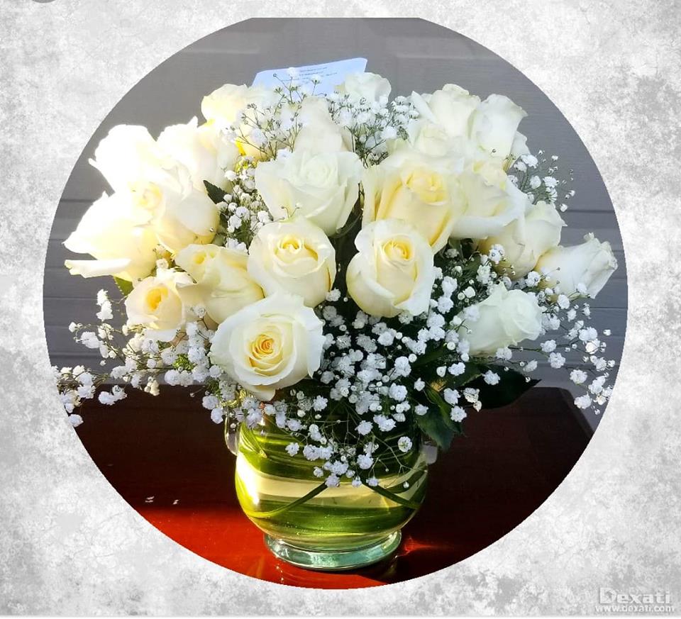 White roses and baby's breath in a glass vase