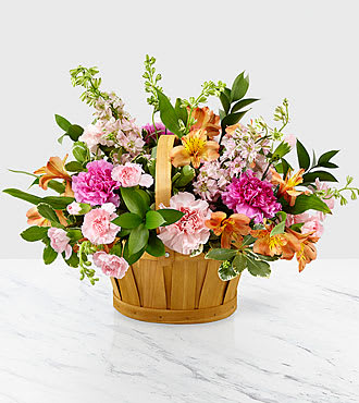 Mixed pink and orange flowers in a wooden basket