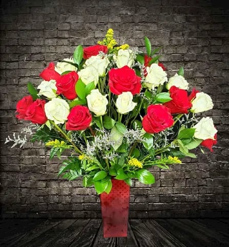 Bouquet of red and white roses in a red vase