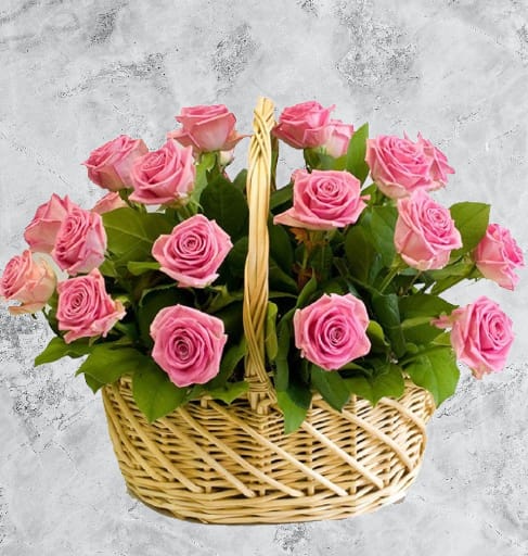 Basket of pink roses with green leaves