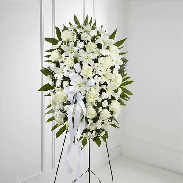 White funeral spray on a stand with ribbon