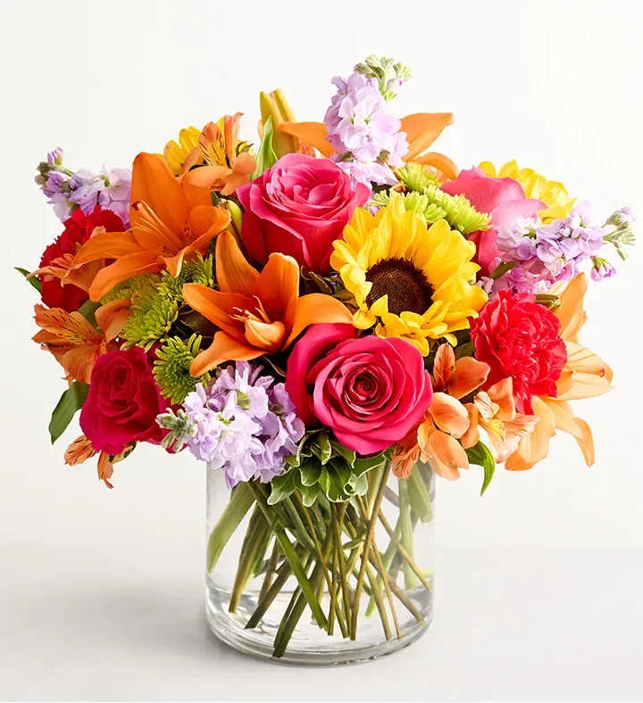 Floral Embrace  - Like a warm embrace, our vibrant flower bouquet delivers your sentiments to someone special. A rich gathering of yellow and orange blooms, with pops of bright pink and purple, it's more than a gift… it's a way to express how you feel